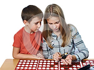 Boy and girl are considering coin collection isolated