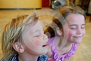 Boy and girl cooling off in front of a fan