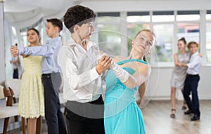 Boy and girl dancing waltz in studio