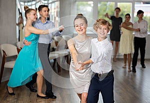 Boy and girl dancing waltz in studio