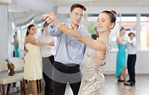 Boy and girl dancing waltz in studio