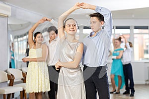 Boy and girl dancing waltz in studio