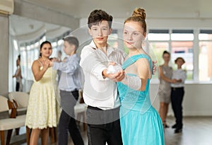 Boy and girl dancing waltz in studio