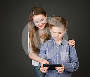 Boy and girl with digital tablet. Interested in technology