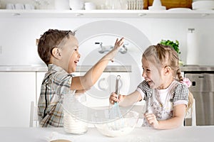 The boy and the girl do dough in kitchen. They play about.