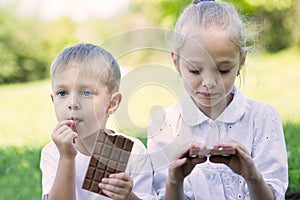 Boy and girl eating chocolate bar