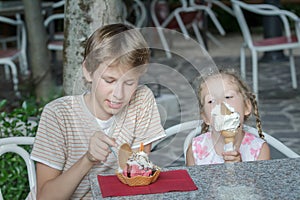 Boy and girl eating Italian gelato in street ice cream bar