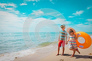 boy and girl with floatie go to beach