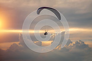 Boy and girl flying on a paraglider on a background of clouds