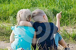 Boy and girl friends brother sister sitting on the ground