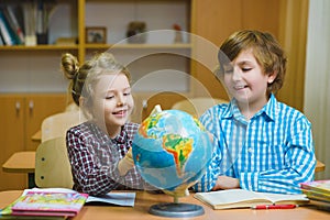 Boy and girl on the geography lesson in school classroom. Educational concept