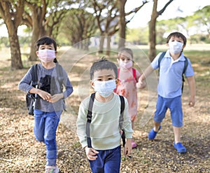 Boy and girl going back to school after covid-19 quarantine and lockdown. Group of kids in masks for coronavirus prevention