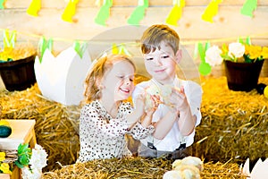 Boy with the girl on hay with chickens