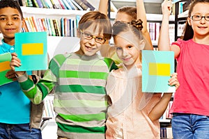 Boy and girl hold exercise books in library