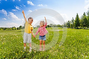 Boy and girl hold hands with second hand up