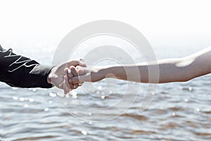 Boy and girl are holding hands on the sea