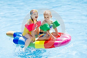 Kids on inflatable float in swimming pool. photo