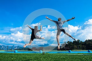 Boy and girl jumping into the pool in the lake.