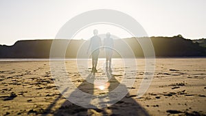 Boy And Girl Laughing Together Walking On A Peaceful Beach