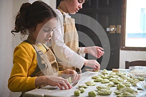 Boy and girl learning culinary at cooking class, making homemade dumplings with mashed potato filling