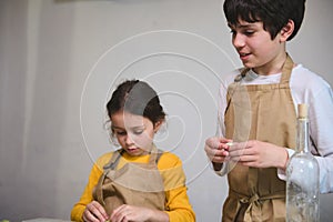 Boy and girl learning culinary at cooking class, making homemade dumplings with mashed potato filling