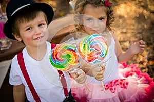Boy and girl children with lollypops candy photo