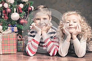 Boy and girl lying on the floor under Christmas tree