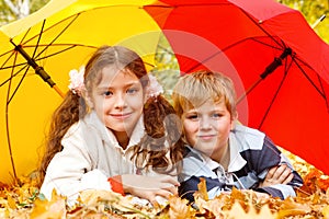 Boy and girl lying on yellow leafage photo