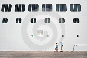 Boy and girl near passenger liner at dock