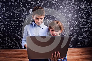 Boy and girl with notebook against big blackboard, school