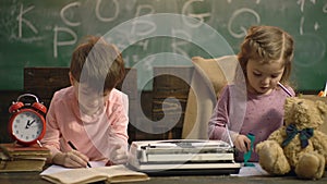 Boy and girl are painting sitting on wooden chairs against the background of a school board. Back to school. Classmate