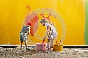 A boy and a girl paints a wall at home