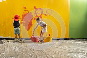 A boy and a girl paints a wall at home