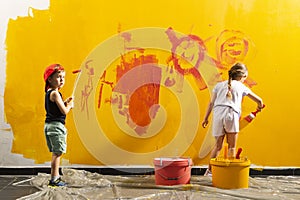 A boy and a girl paints a wall at home