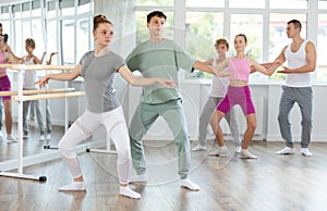 Boy and girl in pair train to perform ballet dance during rehearsal in studio