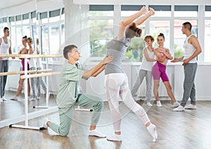 Boy and girl in pair train to perform ballet dance during rehearsal in studio