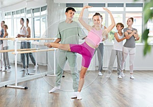 Boy and girl in pair train to perform ballet dance during rehearsal in studio