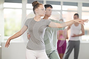 Boy and girl in pair train to perform ballet dance during rehearsal in studio