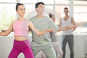 Boy and girl in pair train to perform ballet dance during rehearsal in studio