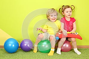 Boy and girl with pigtails sitting on the colorful