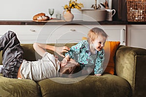 Boy and girl play on the sofa in the children`s bedroom. Brother and sister happily spend time together