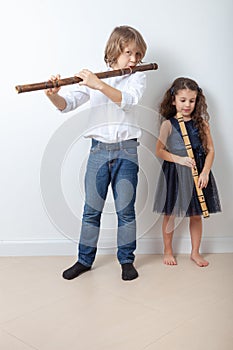 Boy and girl playing bamboo flute