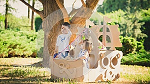 Boy and girl playing in a cardboard boat