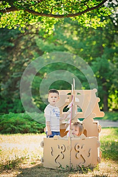 Boy and girl playing in a cardboard boat