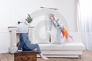 Boy and girl playing cosmonauts at home