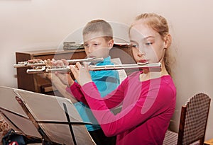 A boy and a girl playing the flute