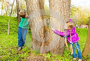 Boy and girl playing hide-and-seek in the forest