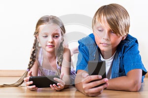Boy and girl playing with mobile phones