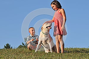 Boy and girl playing with pet dog