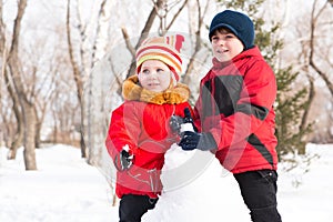 Boy and girl playing with snow in winter park